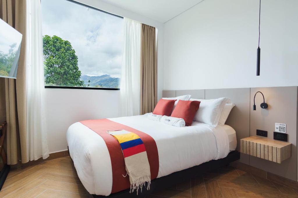 a bedroom with a large bed with a window at Hotel Casa Tama in Salento