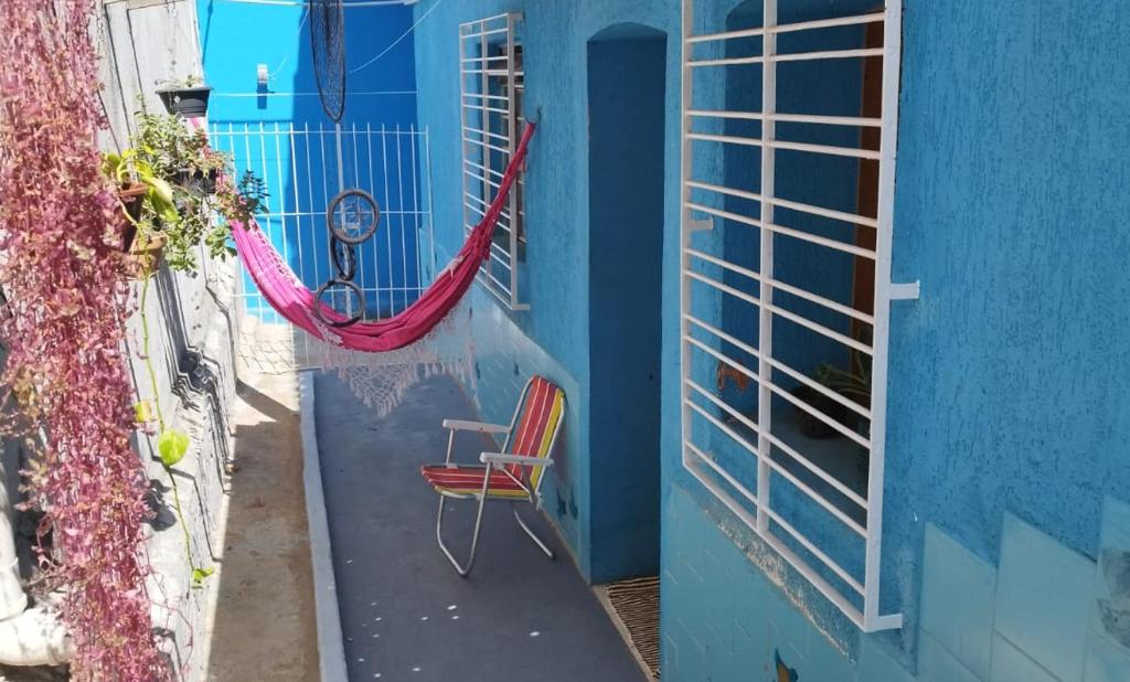 a blue house with a red chair and a window at Casa Azul em Santa Tereza in Belo Horizonte
