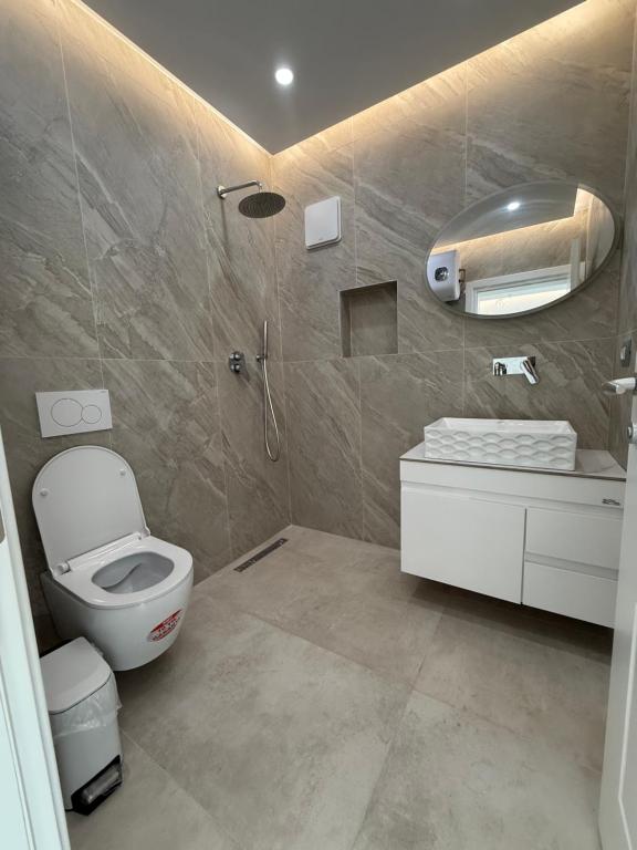 une salle de bain avec des toilettes blanches et un lavabo dans l'établissement Dashaj Rooms 301, à Ksamil