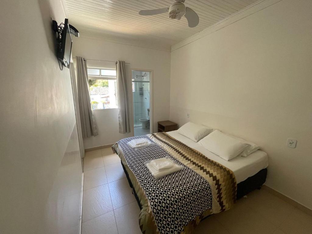 una camera con letto, finestra e soffitto di POUSADA VILA DO BIRIBIRI EXCLUSIVAMENTE DENTRO da VILA DO BIRIBIRI a Diamantina