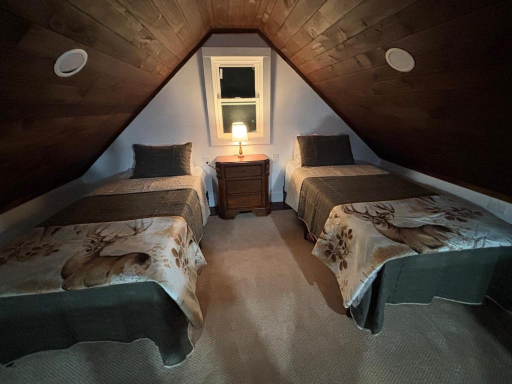 a attic room with two beds and a lamp at Lake Eagle Rock Lodge in Eagle Rock