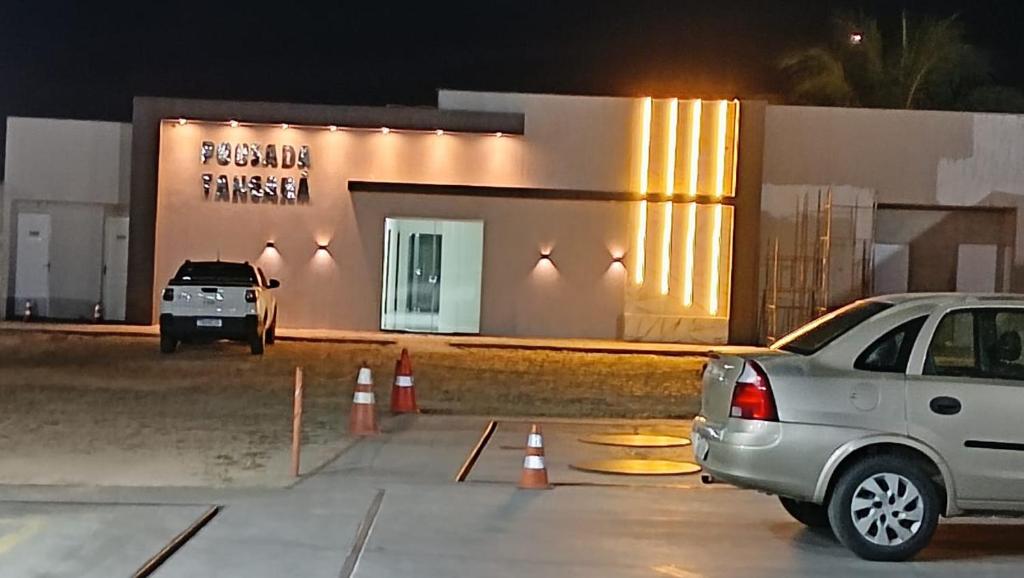 a car parked in a parking lot in front of a building at Pousada Tangará 