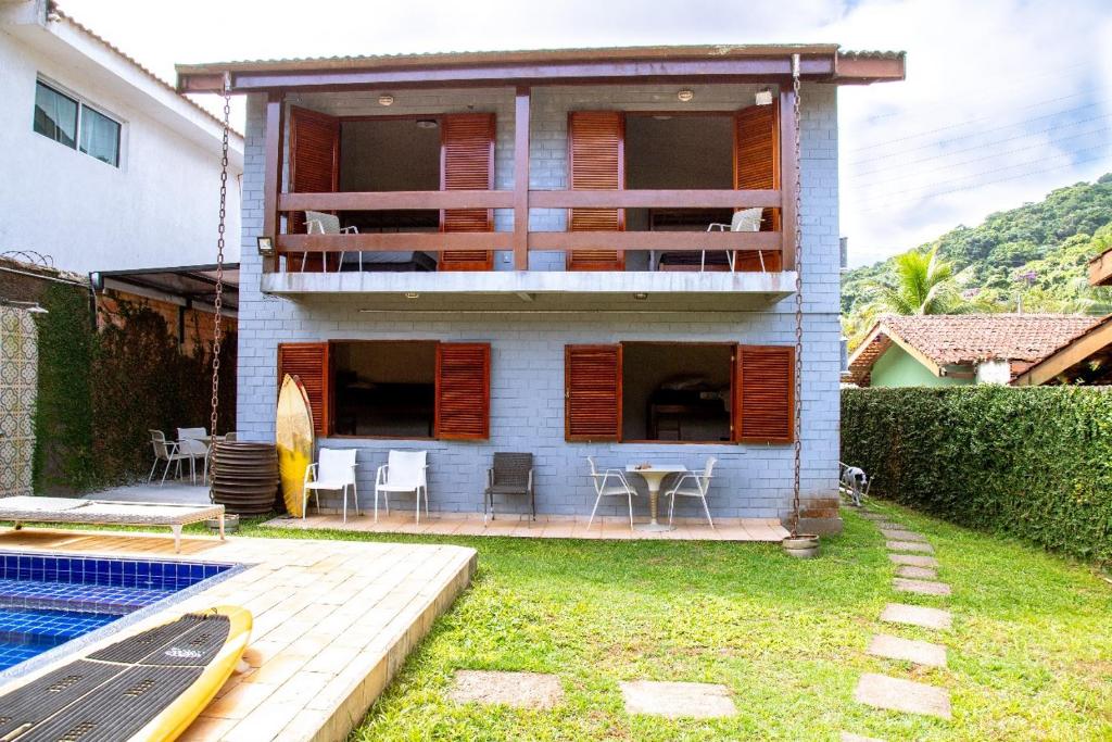 a house with a deck and a swimming pool at Casarão do Coronel - Descanso e lazer em Maresias na Praia do Saco in Maresias