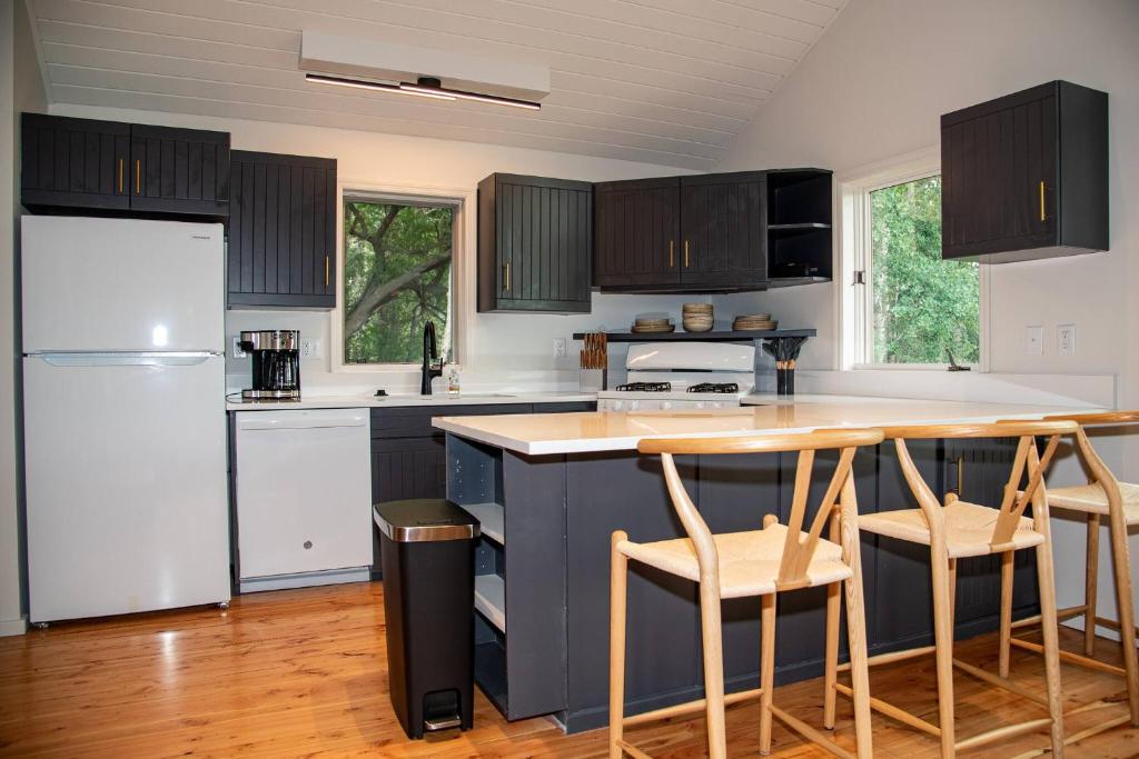 a kitchen with black cabinets and a white refrigerator at Black Bear Bungalow w/Hot Tub! in Gallatin Gateway