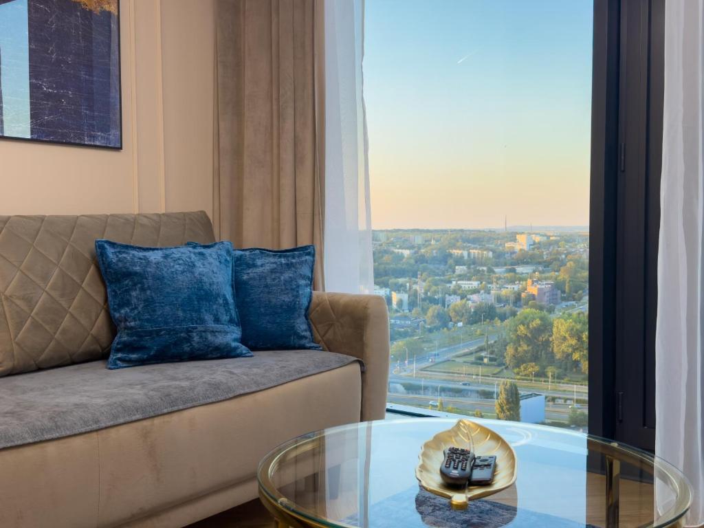Una sala de estar con un sofá y una mesa de cristal. en URBAN APARTMENTS GLOBAL SkyLine, 25th floor No 05, Free Garage, Self Check-in, No Deposit, en Katowice