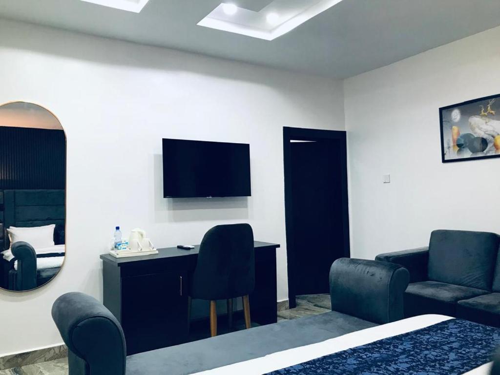 una stanza con un letto, una scrivania e una sedia di Zustel Hotel and Suites a Enugu