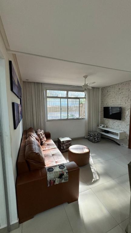 a living room with a couch and a tv at Conforto e localização in Vila Velha