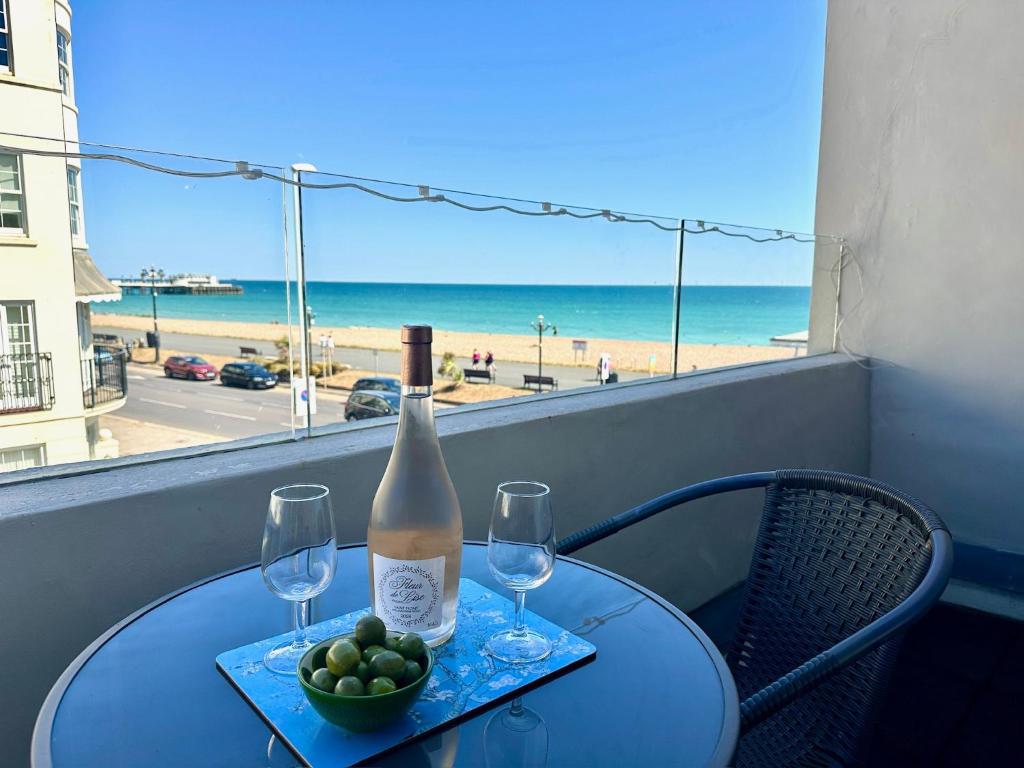a table with a bottle of wine and two glasses at House by the Sea, Worthing in Worthing