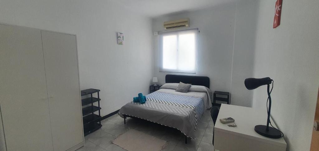a bedroom with a bed and a desk and a window at Habitación Matrimonio Espaciosa en Vivienda Compartida in Valencia
