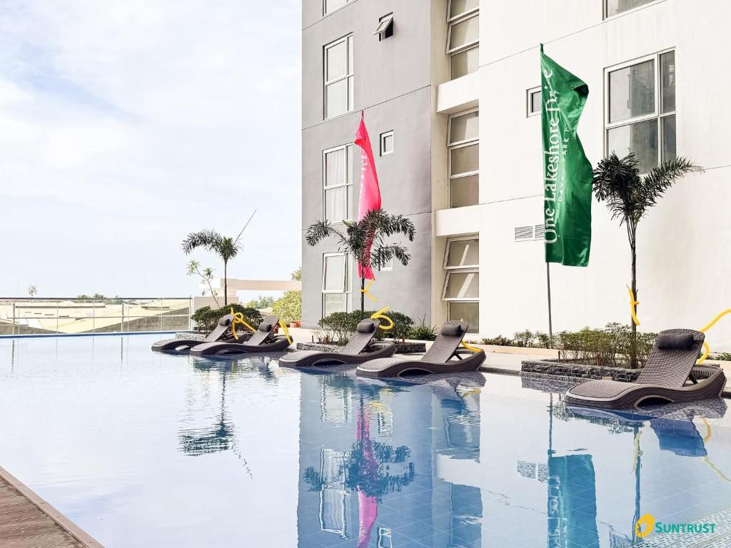 a hotel with a swimming pool in front of a building at Juvycondo in Davao City
