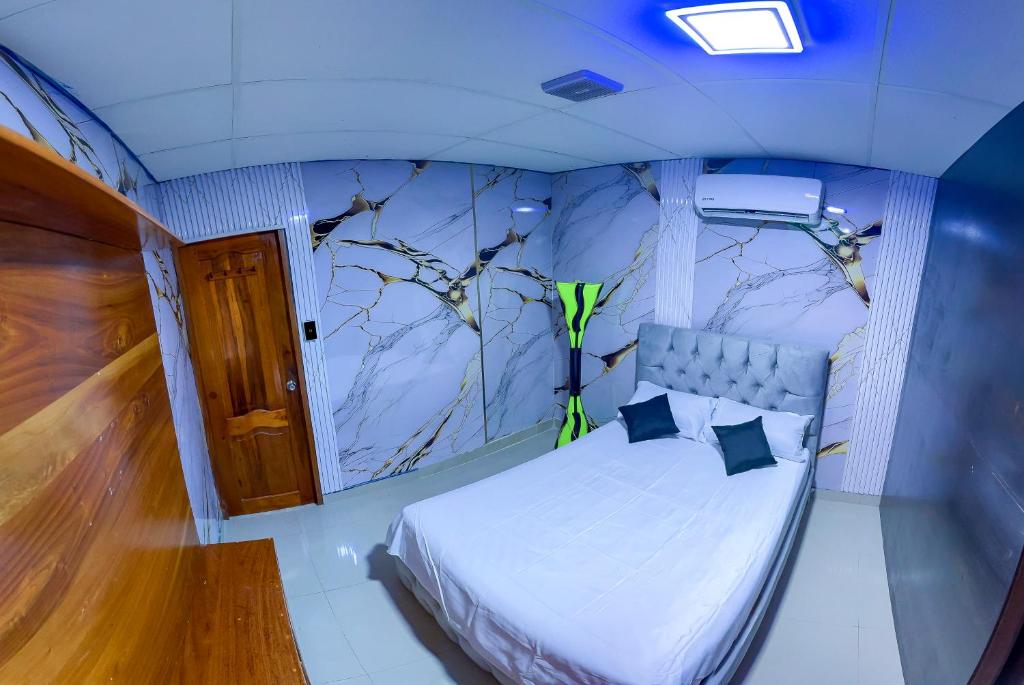 Un dormitorio con una cama con un cuadro en la pared. en Descubre el Paraíso en Isla Isabela Apartamento a un Paso de la Playa, en Puerto Villamil