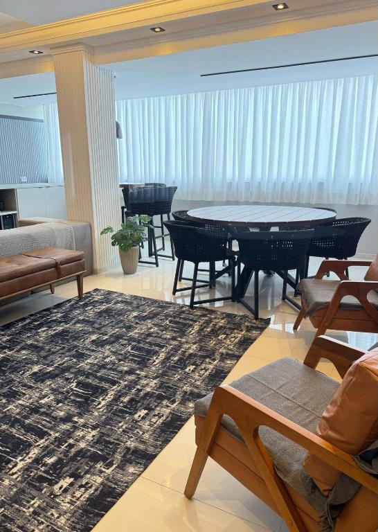 un salon avec une table et des chaises dans l'établissement Apartamento Lindo com sacada vista mar! Pé na areia!!!, à Guarujá
