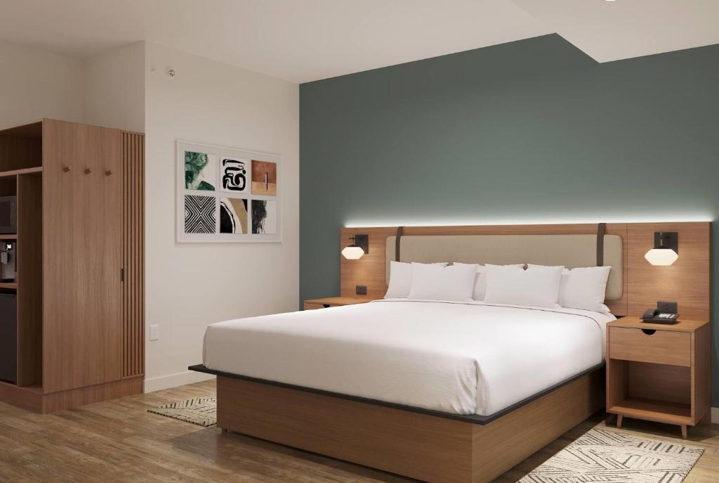 a bedroom with a large white bed and a cabinet at Hawthorn Extended Stay by Wyndham Kilgore in Kilgore