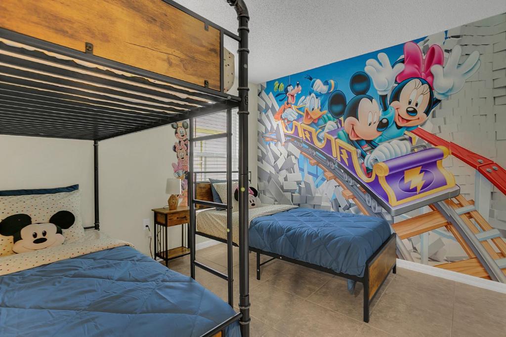 ein Schlafzimmer mit einem Etagenbett und einem Mausemuster in der Unterkunft Dream Stay Orlando with a pool and home theater in Davenport