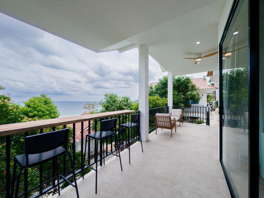 a balcony with chairs and a view of the ocean at v5 Sea Breeze Home in Haad Yao
