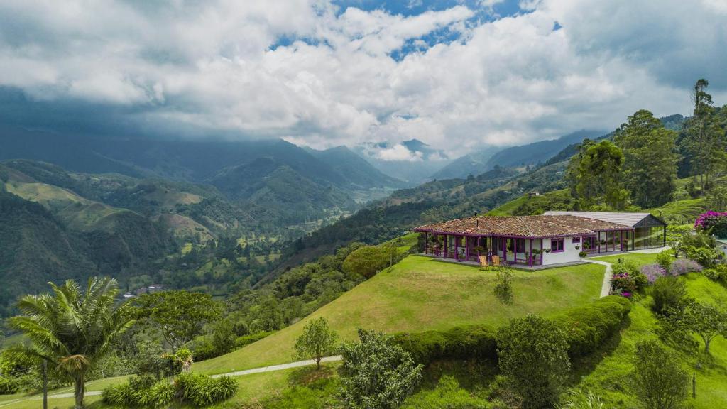 a house on a hill with a view of mountains at La Casa en las Nubes in Salento
