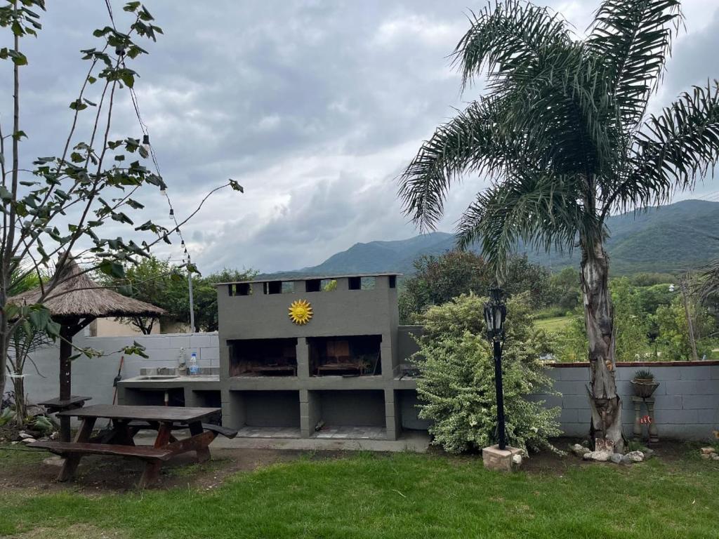 Un edificio con una mesa de picnic y un girasol encima. en COMPLEJO AyH, en Malagueño