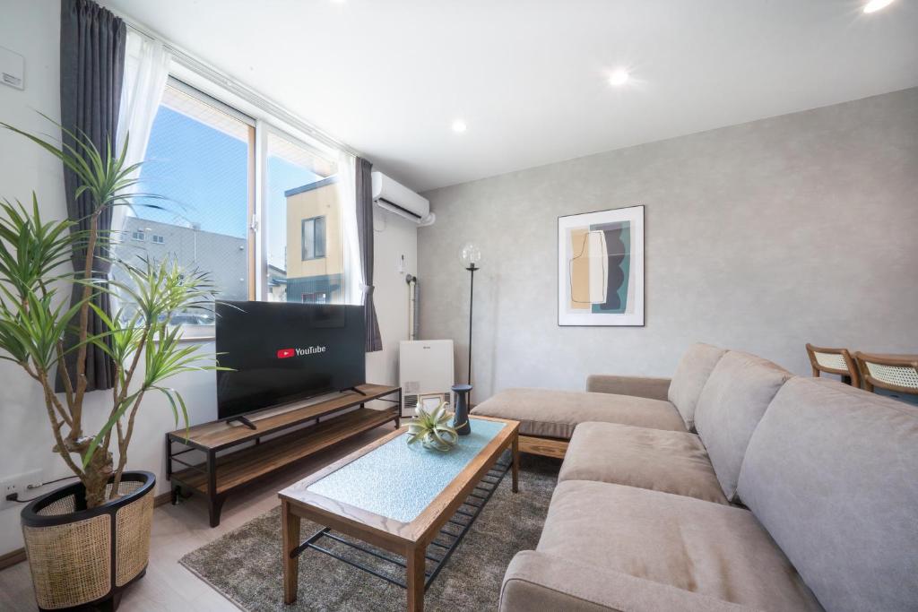 a living room with a couch and a tv at Mks 102 in Asahikawa