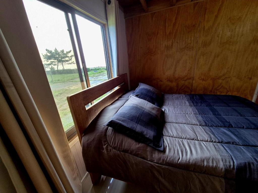 a small bed in a room with a window at Curaquilla Beach in Arauco