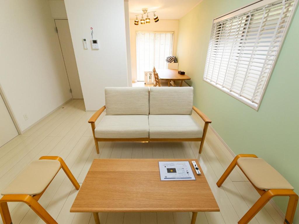 a living room with a coffee table and two chairs at Kinugawa Station Front room A in Nikko