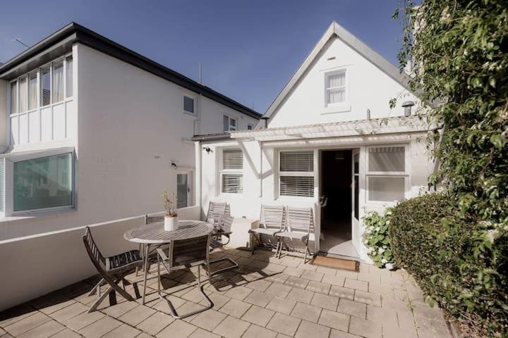 a patio with a table and chairs and a white house at Kelly Street Cottage in Historic Battery Point in Hobart