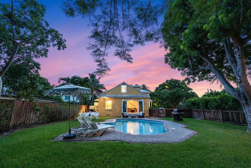 a backyard with a swimming pool and a house at Heated Pool Grill Fire Pit & Cold Plunge Sleeps 8! in West Palm Beach