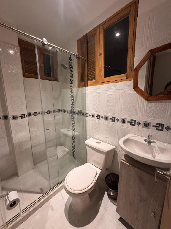 a bathroom with a shower and a toilet and a sink at LA VICTORIA Casa tropical con piscina privada in Carmen de Apicalá
