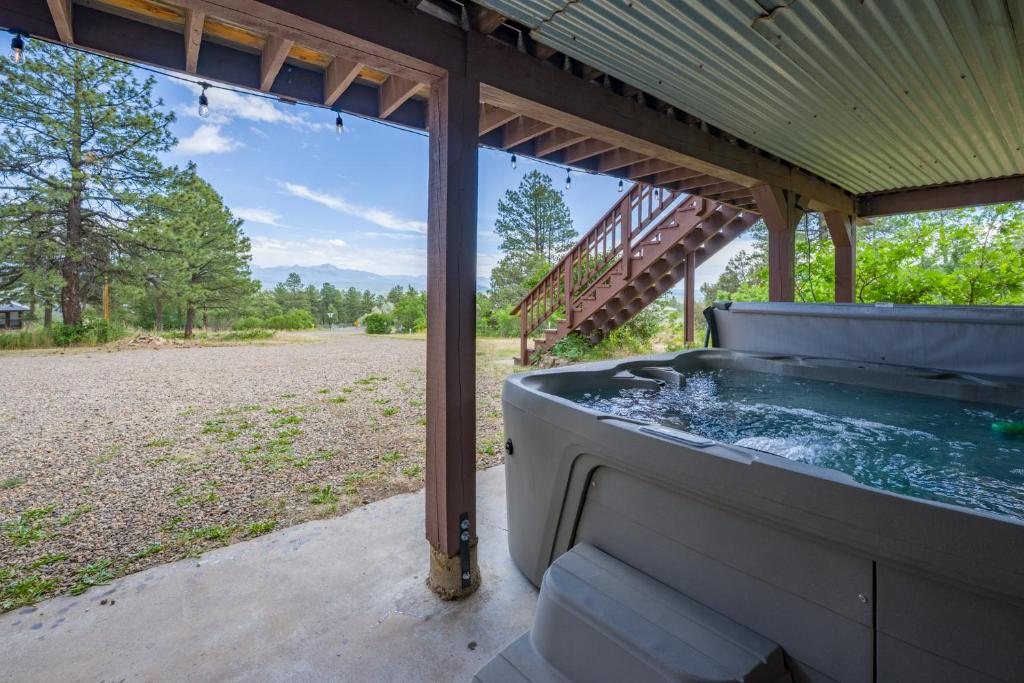 einen Whirlpool auf der Veranda eines Hauses in der Unterkunft Hot Tub + Views | Cozy Retreat in Pagosa Springs