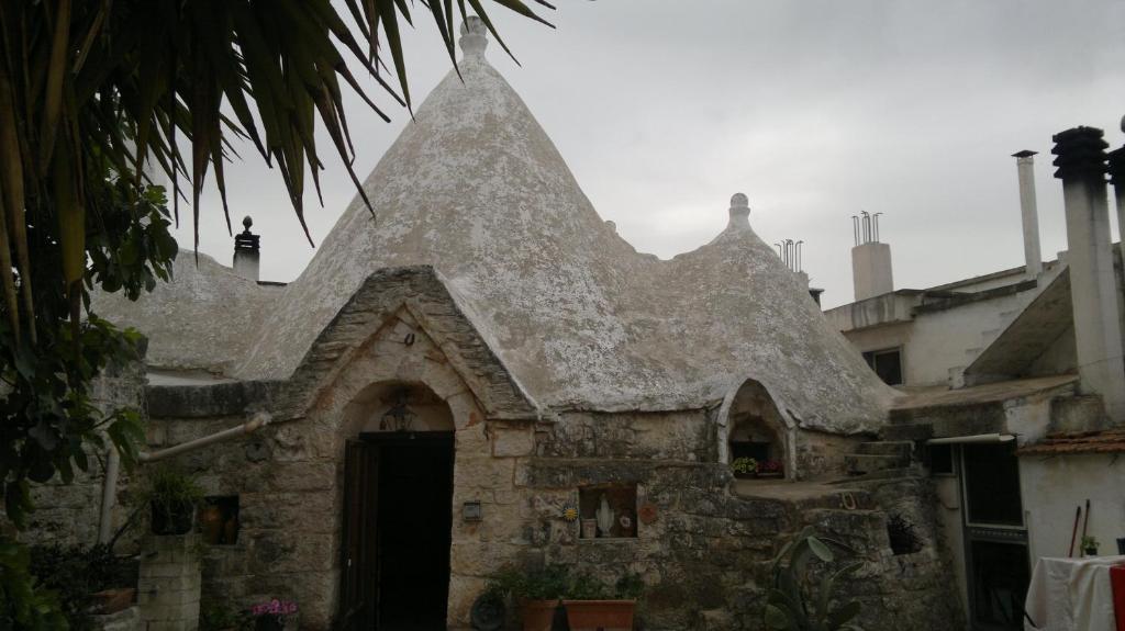 an old stone building with a pointed roof at Masseria Donna Licia in Pezze di Greco