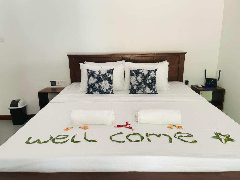 a bed with the words well coming written on it at Beach Resort Paradise Bungalows in Trincomalee