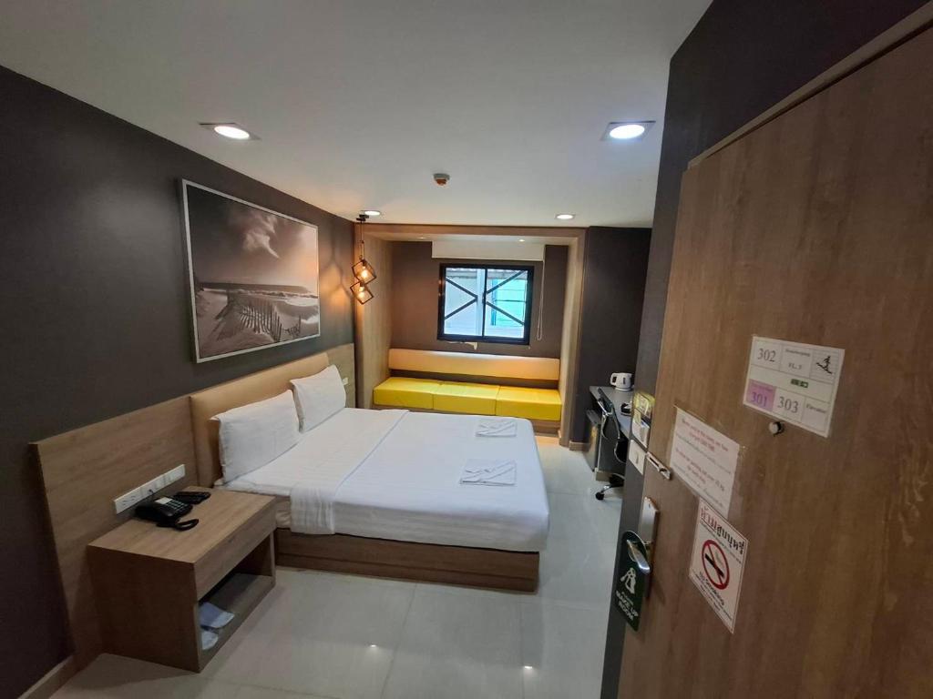 a small bedroom with a bed and a window at Collection O Pratunam 19 Hotel in Bangkok