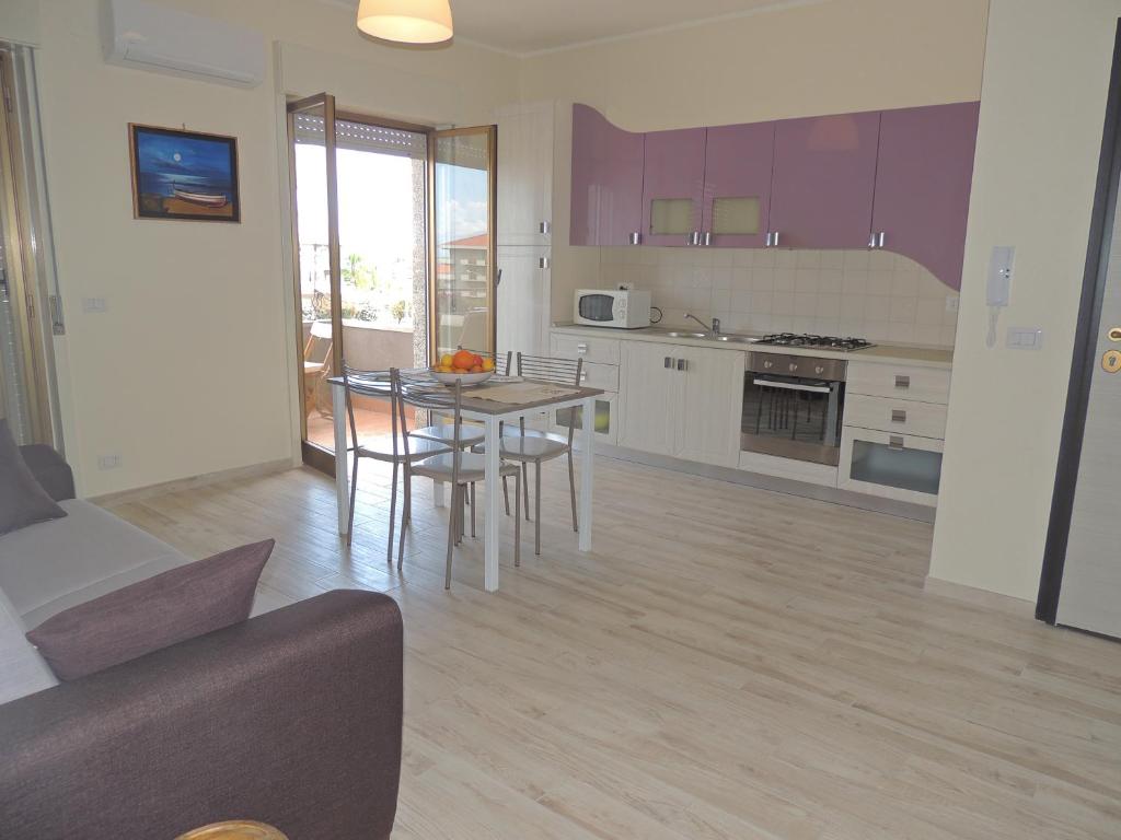 Il comprend une cuisine et un salon avec une table et des chaises. dans l'établissement Apartment I Mastrazzi, à Riposto