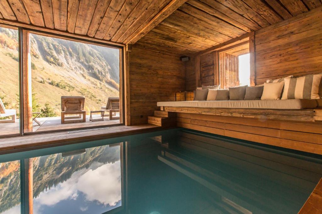 a bedroom with a bed and a swimming pool at Chalet 1864 in Le Grand-Bornand