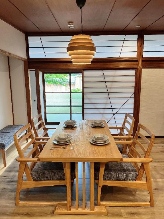 a wooden dining room table with chairs and a chandelier at HOTEL DanDan in Shuzenji
