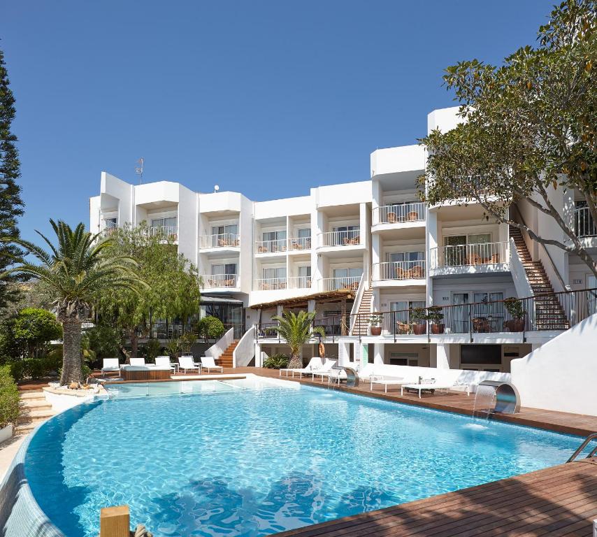 an image of a swimming pool in front of a building at Apartamentos Castaví in Es Pujols