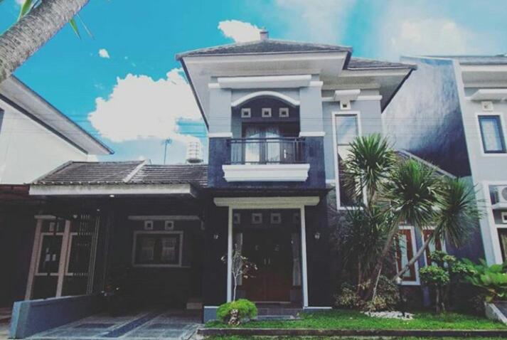 a black and white house with a balcony at Stylish House Near Pakuwon Mall in Kejayan
