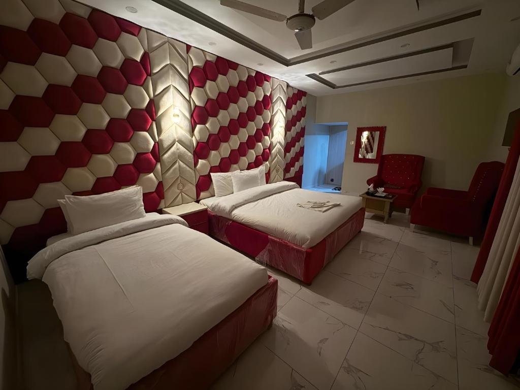una habitación de hotel con dos camas y una silla en Decent Luxury Guest House F-10, en Islamabad