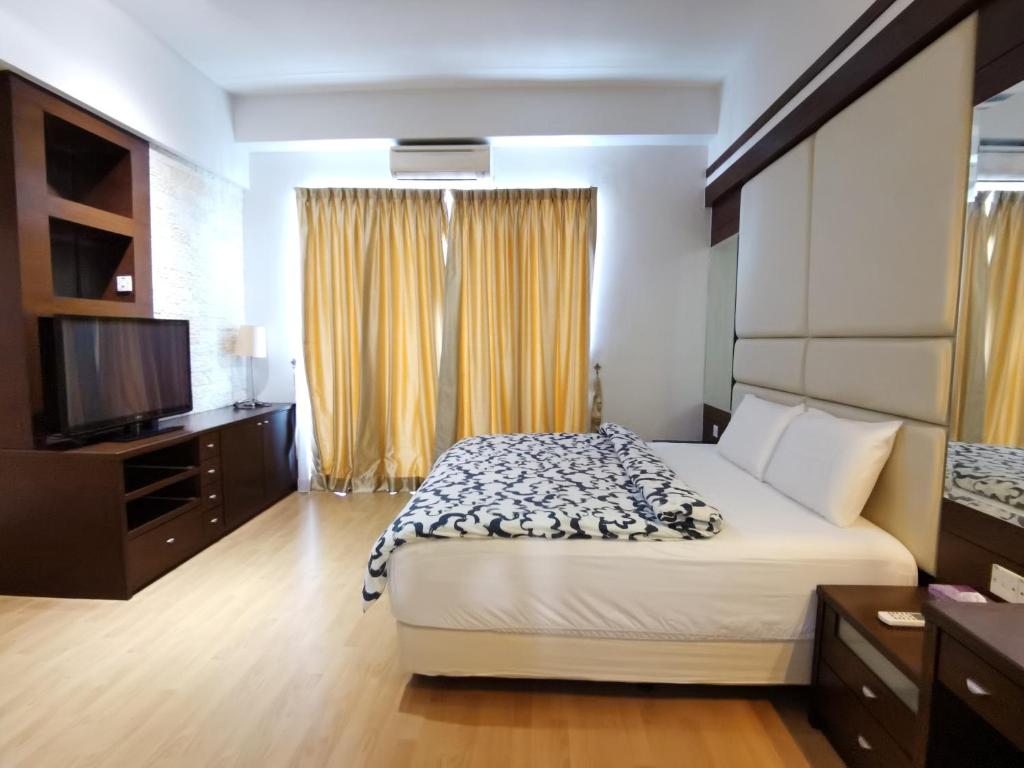a bedroom with a bed and a flat screen tv at Seri Bukit Ceylon By SS in Kuala Lumpur