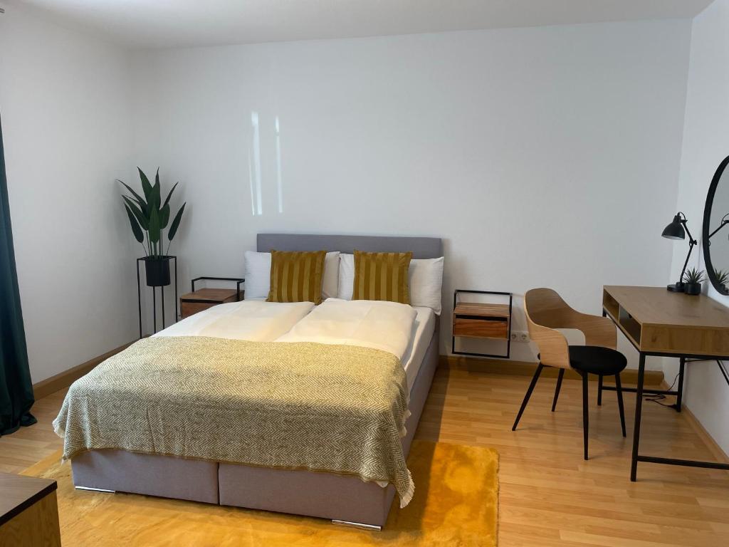 a bedroom with a bed and a table and a desk at Fewo Zentral-Living in Kempten