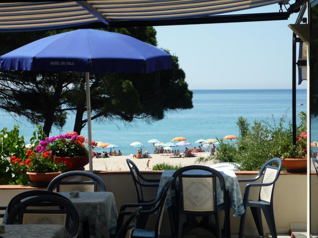 uma mesa e cadeiras com vista para a praia em Hotel Da Italo em Seccheto