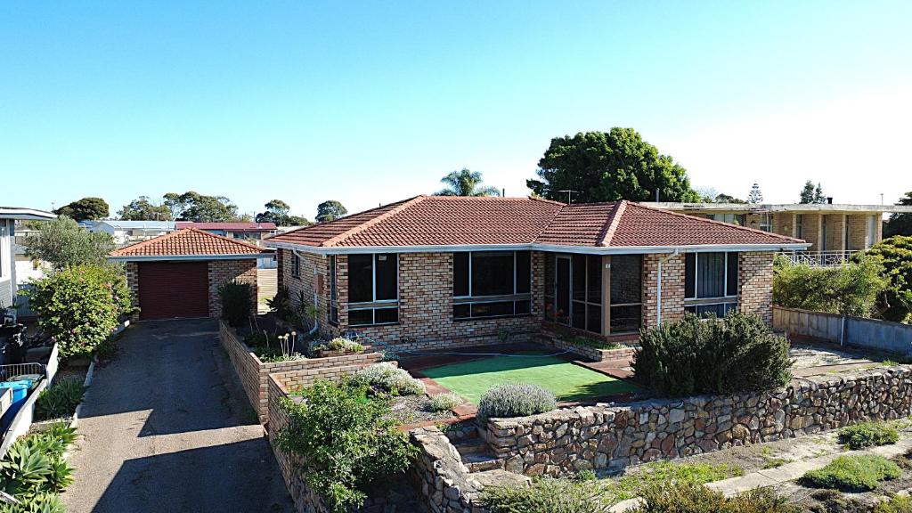 a brick house with a retaining wall and a yard at Smugglers Cove in Esperance