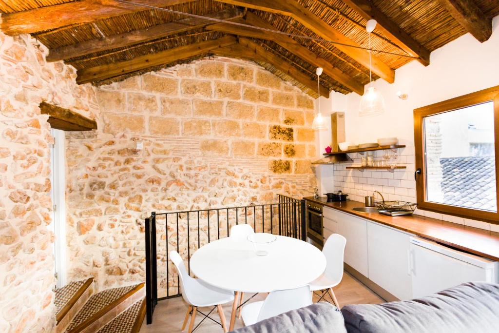 a kitchen and living room with a white table and chairs at Casa San Pascual in Denia
