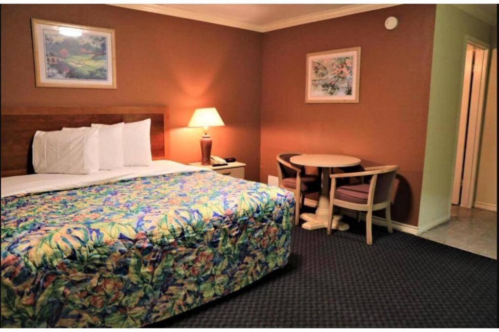 a hotel room with a bed and a table at Capital O Hotel Beeville - US 181 in Beeville