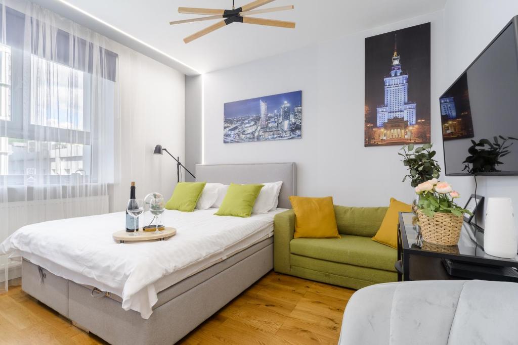 un dormitorio con una cama y un sofá en Lumina apartments next to Rondo ONZ, en Varsovia