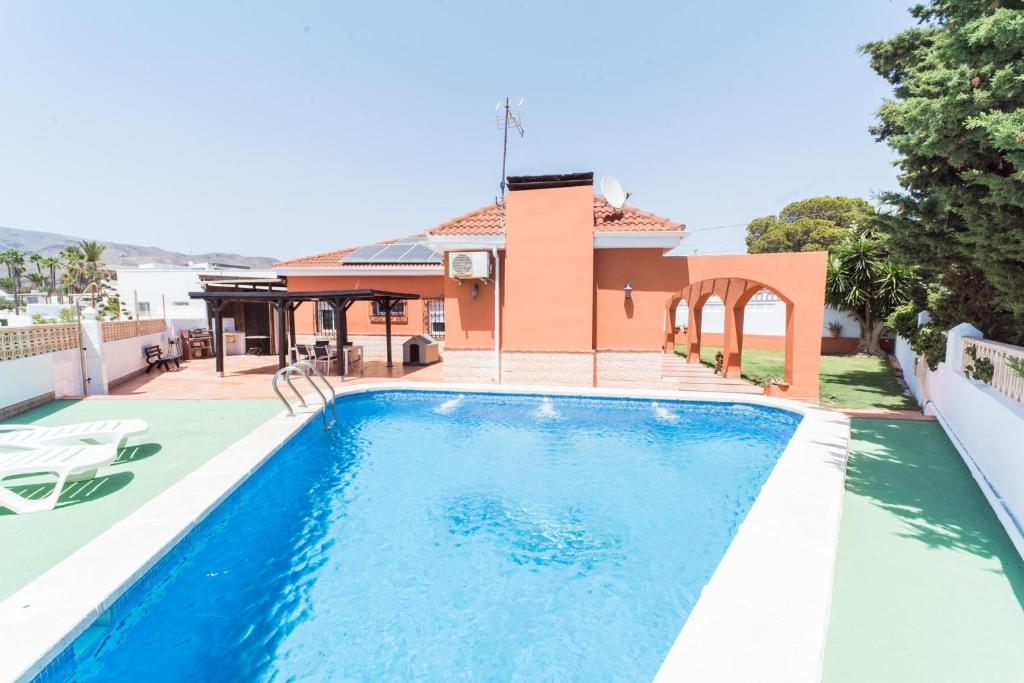 a swimming pool in front of a house at Expoholidys- Chalet privado en Castell del Rey in Almería