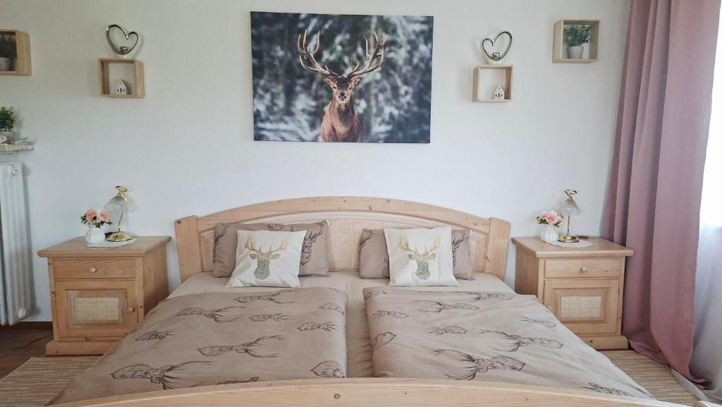 a bedroom with a bed with two night stands and a deer picture at Hengeler's hof in Altusried