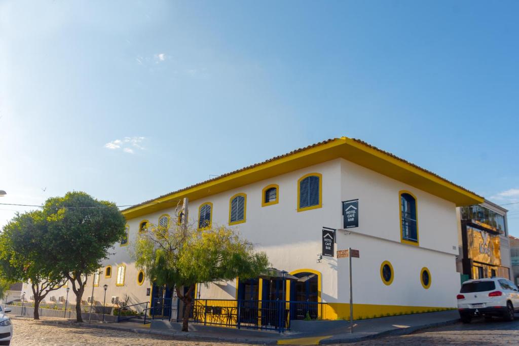 a large white building with a yellow roof at Hotel do Baú in Santa Rosa de Viterbo