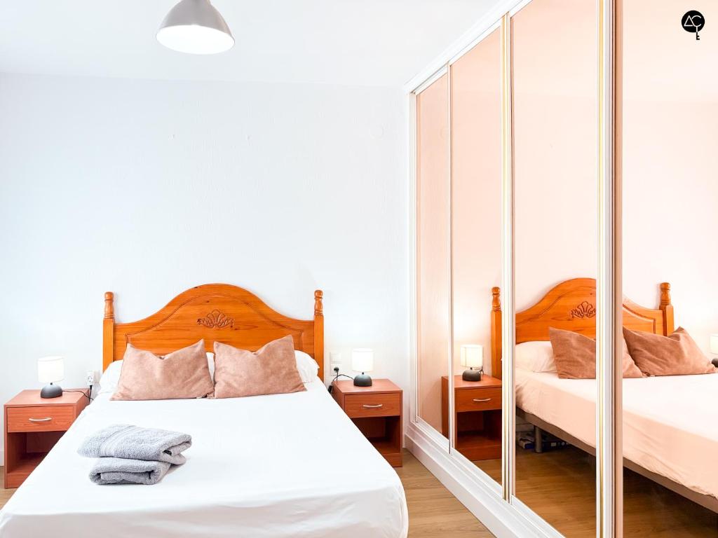 Un dormitorio con dos camas y un espejo. en Apartamento La Caleta Grupo AC Gestion, en Cádiz