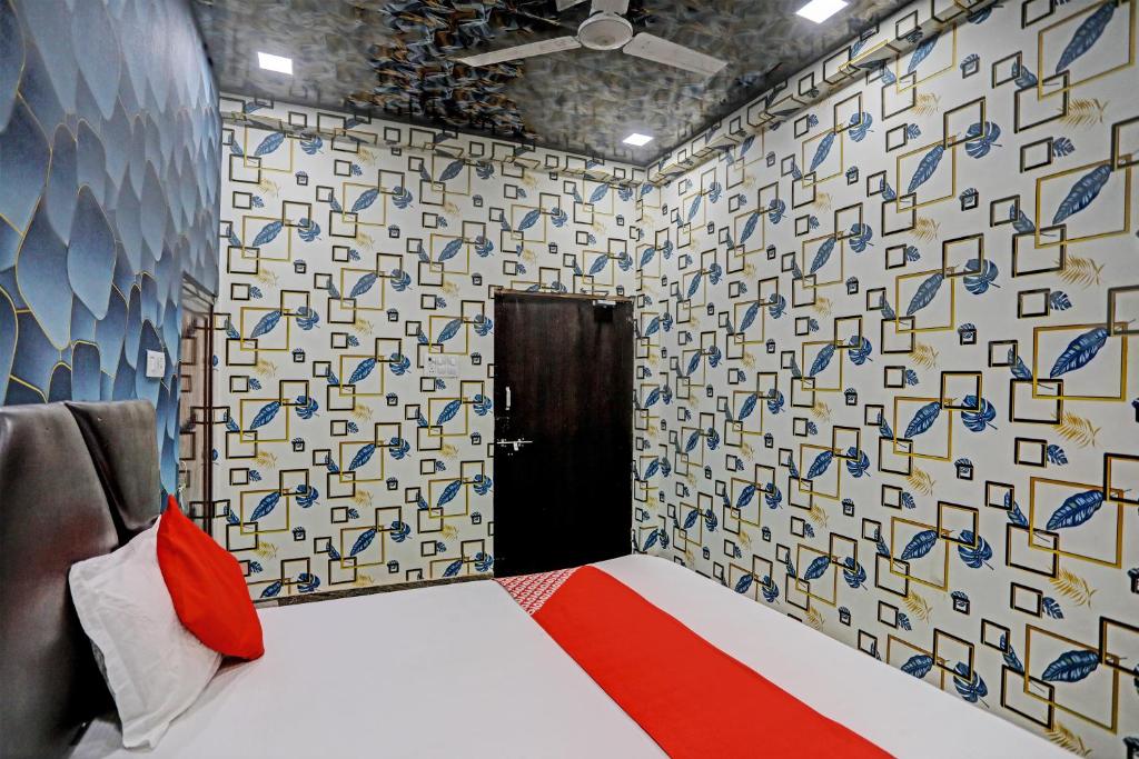 a room with a bed and a wall with a pattern at Hotel O New Jagrani palace in Kānpur