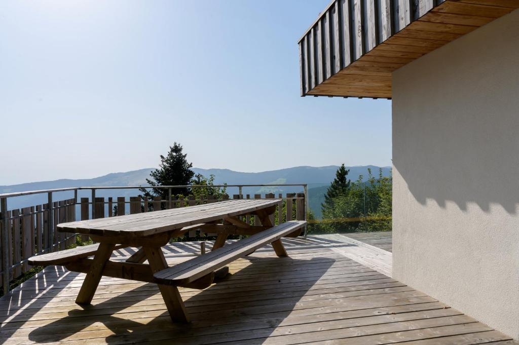 a wooden picnic table on a balcony with a view at Refuge Mil100 Chalet-spa Luxe 5 in Metzeral